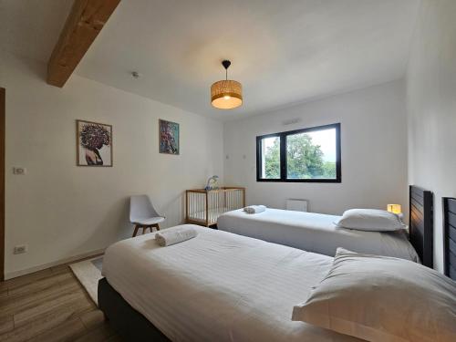 a bedroom with two beds and a window at Les Quatre Baies in Guichen