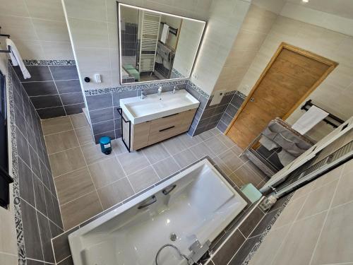 a bathroom with a tub and a sink and a mirror at Les Quatre Baies in Guichen