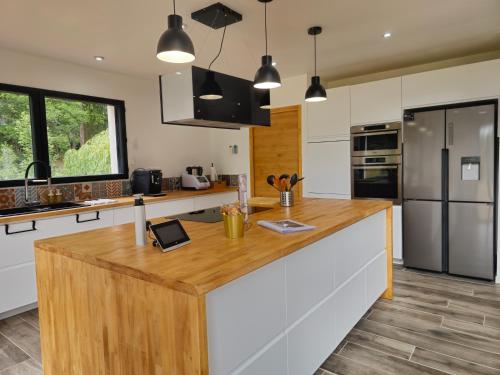 a kitchen with a large wooden island in the middle at Les Quatre Baies in Guichen