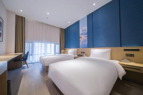 a hotel room with two beds and a desk at Atour X Hotel Kunming Old Street Wuyi Road in Kunming