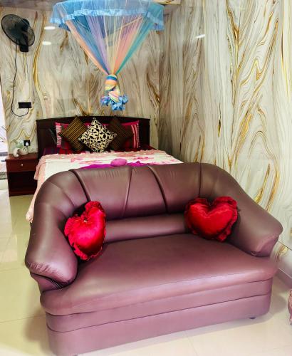 a brown leather couch with two red hearts on it at Grand adamspeak hotel & restaurant in Adams Peak