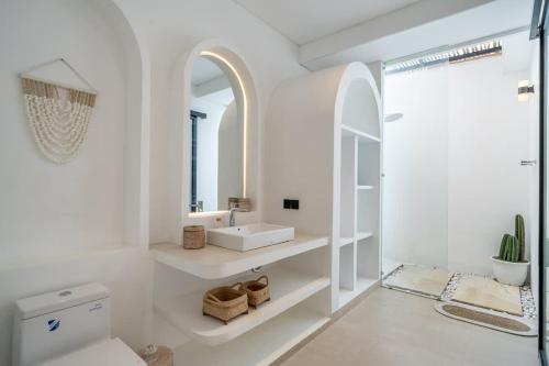 ein weißes Badezimmer mit Waschbecken und Spiegel in der Unterkunft Modern 2BR Villa in Bingin V1 in Uluwatu