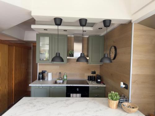 a kitchen with green cabinets and a sink at Panorama Marilleva 1400 - Val di Sole in Marilleva
