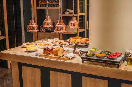 a buffet with many different types of food on a table at FirstName Toulouse, part of JdV by Hyatt in Toulouse