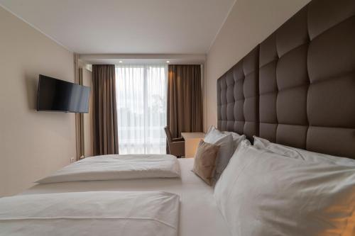 a hotel room with two beds and a large window at Pakat Residences in Vienna