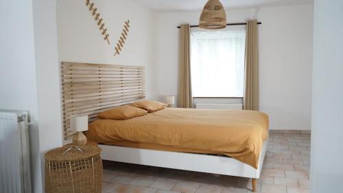 a bedroom with a large bed and a window at La Maisonnette - 2 chambres, parking, jardinet & calme in Tournai
