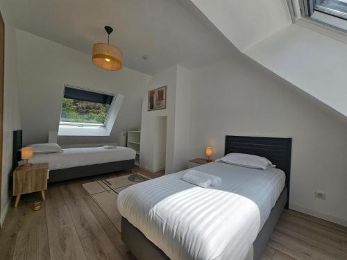 a bedroom with two beds and a window at Les Quatre Baies in Guichen