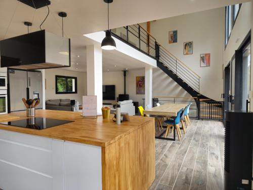 an open kitchen and dining room with a dining table at Les Quatre Baies in Guichen