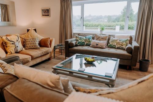 a living room with couches and a table at A Spacious Countryside Retreat for up to 16 Guests in Llanarthney