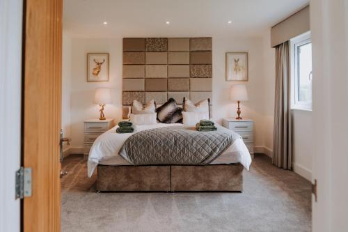 a bedroom with a large bed with two lamps on tables at A Spacious Countryside Retreat for up to 16 Guests in Llanarthney
