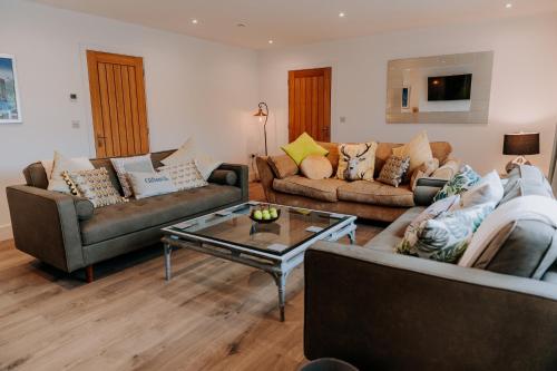 a living room with two couches and a coffee table at A Spacious Countryside Retreat for up to 16 Guests in Llanarthney