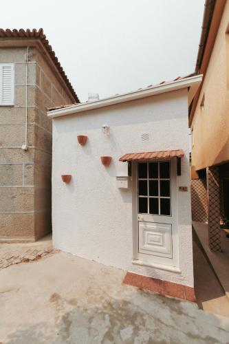 a white building with a door on the side at Casinha do Douro, Cinfães in Escamarão