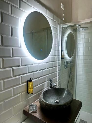 a bathroom with a black sink and a mirror at Ginevra Boutique Rooms - Palazzo Leosini - Residenze D'Epoca in LʼAquila