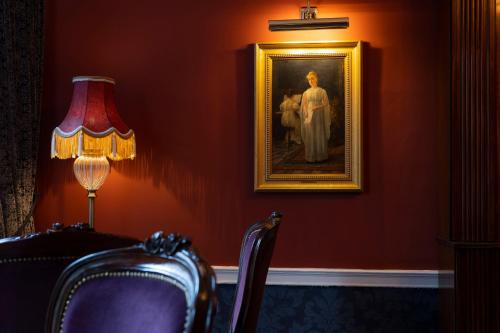 a lamp and a picture of a woman in a room at Stauntons on the Green Hotel in Dublin