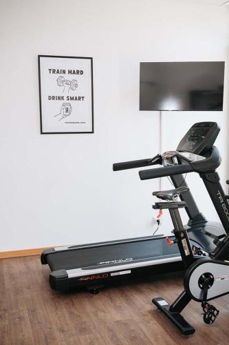 a room with a treadmill next to a wall at Coffee Fellows Hotel München-Freiham in Munich