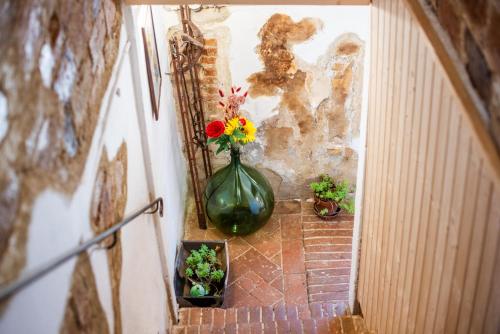 a green vase with flowers sitting on a wall at Traveling_spoon in Belforte