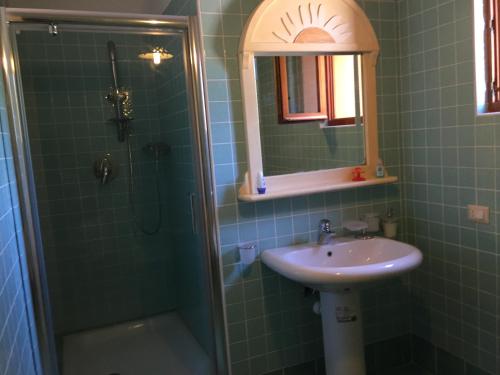 a bathroom with a sink and a shower with a mirror at Casa Alberto in SantʼAndrea