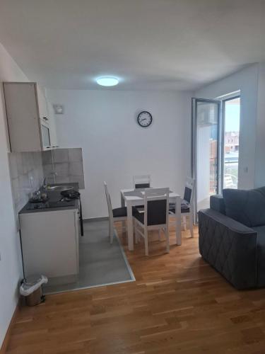 a living room and kitchen with a table and a couch at Apartman MBV Vrnjačka Banja in Vrnjačka Banja