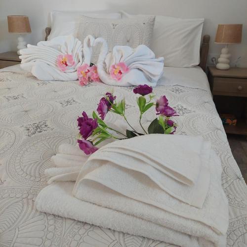 two swans towels and flowers on a bed at The Mastiha Spot 4 in Chios