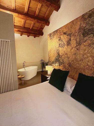 a bedroom with a bed and a bath tub and a bath tub at Ginevra Boutique Rooms - Palazzo Leosini - Residenze D'Epoca in LʼAquila