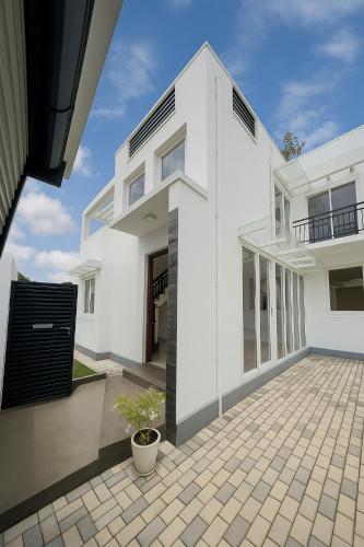 a white house with a courtyard in front of it at Green Oasis Colombo Airport By J-Villas in Maeliya