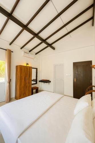 a bedroom with a large white bed and a window at Green Oasis Colombo Airport By J-Villas in Maeliya