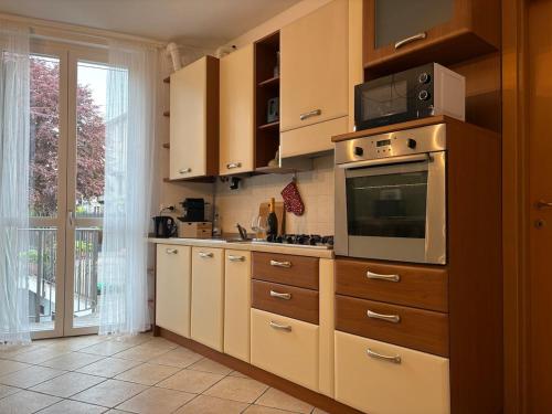 a kitchen with wooden cabinets and a microwave at Lake Como - Casa Mafy in Bellano
