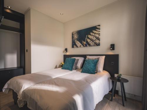 a bedroom with a large white bed with blue pillows at Luxurious holiday home nearby the Lower Rhine in Maurik