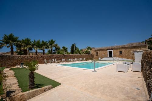 a patio with a pool and chairs and a building at Feudo Nobile in Gela