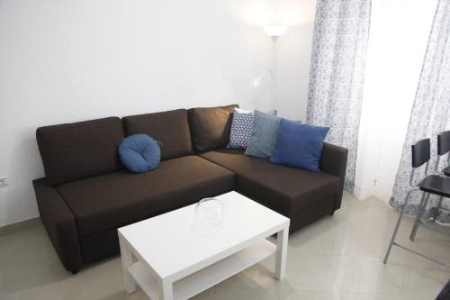 a living room with a brown couch and a white table at Fantástico Piso, Junto a Playa y Pleno Centro in Cádiz