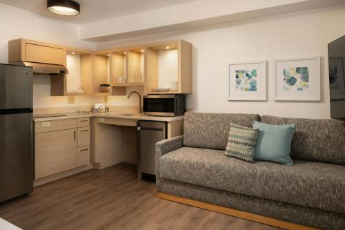 a living room with a couch and a kitchen at TownePlace Suites Milpitas Silicon Valley in Milpitas