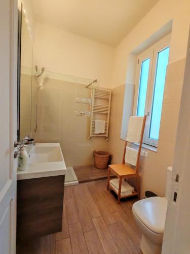 a bathroom with a sink and a toilet and a chair at Villa Miami Taormina in Taormina