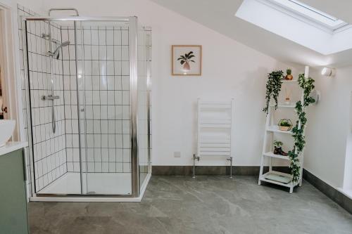 a shower with a glass door in a room at A Spacious Countryside Retreat for up to 16 Guests in Llanarthney
