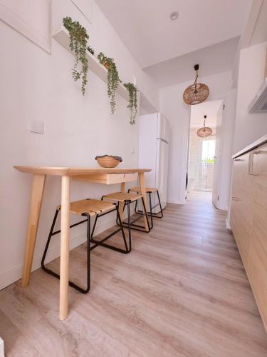 a dining room with a table and some plants on the wall at Sibs Sanlucar - casita playa - coqueto vistas in Sanlúcar de Barrameda