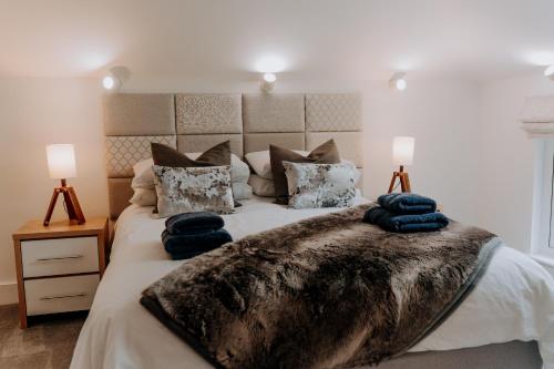 a bedroom with a large bed with pillows on it at A Spacious Countryside Retreat for up to 16 Guests in Llanarthney