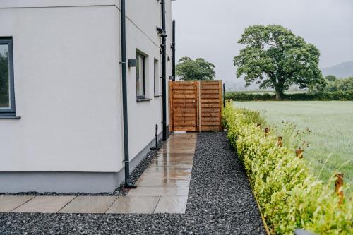 a door to a house with a field in the background at A Spacious Countryside Retreat for up to 16 Guests in Llanarthney