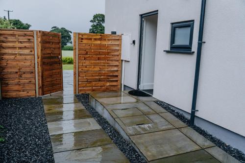 an open door to a house with a fence at A Spacious Countryside Retreat for up to 16 Guests in Llanarthney