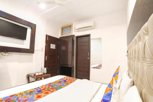 a small bedroom with a bed and a tv at Hotel Madhuban inn rishikesh in Rishīkesh