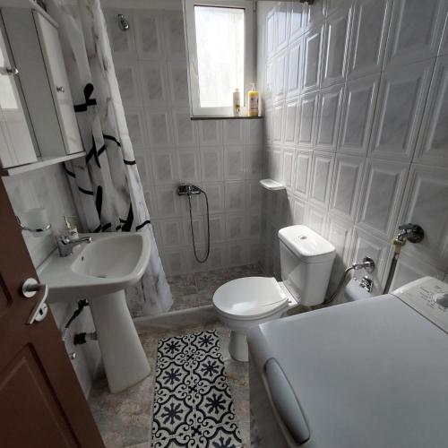 a white bathroom with a toilet and a sink at The Mastiha Spot 4 in Chios