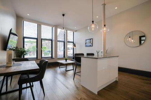 a living room with a table and chairs and windows at Campbell Street Apartments in Oban