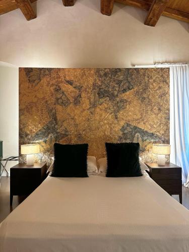 a bedroom with a large bed in front of a wall at Ginevra Boutique Rooms - Palazzo Leosini - Residenze D'Epoca in LʼAquila