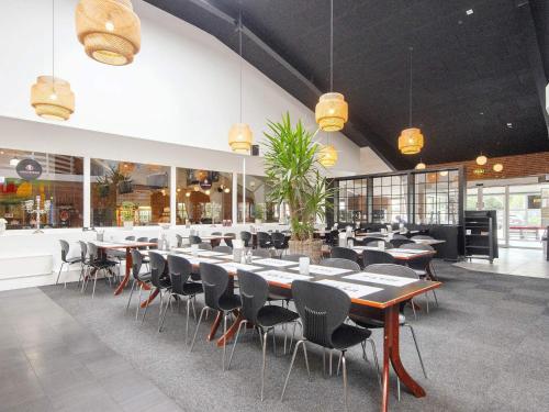 a dining room with tables and chairs in a restaurant at Ho Holiday Center in Blåvand