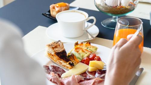 a person eating a plate of food and a cup of coffee at Villa Mosca Charming House in Alghero