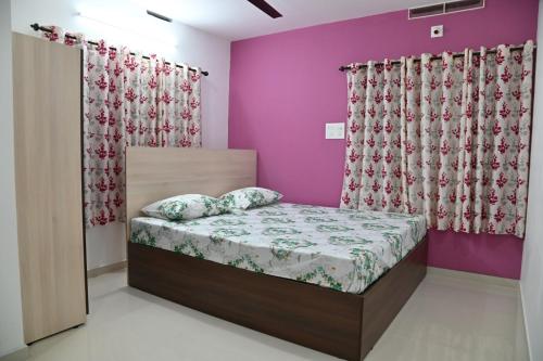 Un dormitorio con una cama con paredes y cortinas moradas. en Rajendra Tourist Home, en Trivandrum