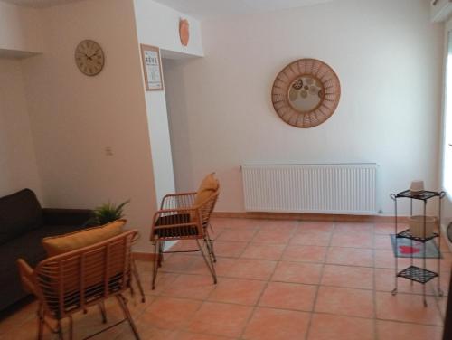 a living room with chairs and a clock on the wall at Chez Dominique et Jean-Louis - Logement T2 50m2 in Tourves