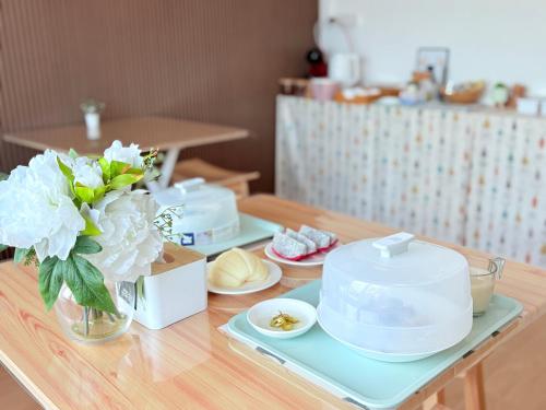 un tavolo con tre piatti e dei fiori sopra di Na KlongMuang B2 a Phra Nakhon Si Ayutthaya
