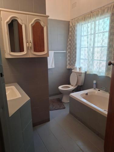 a bathroom with a tub and a toilet and a sink at Ruitersrust in Fauresmith
