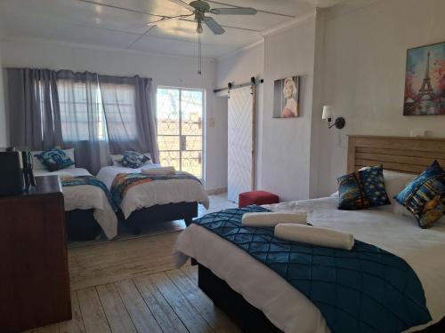 a bedroom with two beds and a ceiling fan at Ruitersrust in Fauresmith