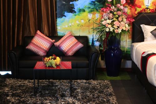 a living room with a couch and a vase of flowers at D11 Hotel in Phitsanulok