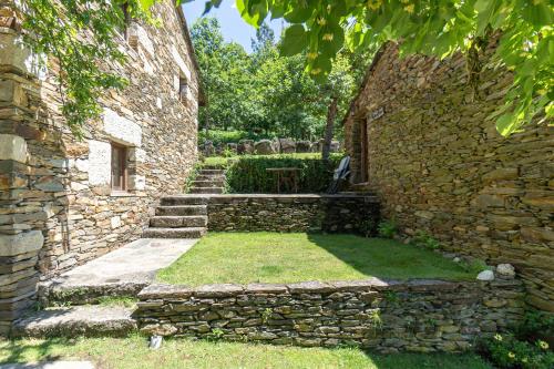 a stone building with a bench in a yard at Quinta da Rabaçosa - Turismo Rural in Castro Daire